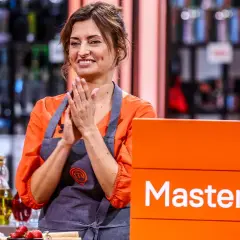 Barbara Tomkowiak w fartuchu MasterChef, z dłońmi złożonymi w geście radości.
