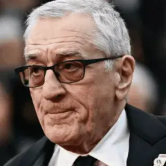 Portret Roberta De Niro w okularach, w garniturze.