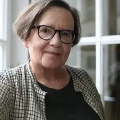 Portret starszej kobiety w okularach, w kratowanej koszuli.