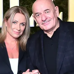 Marcin Daniec z żoną na tle zielonej ściany z ozdobnymi literami.