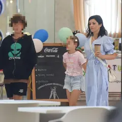 Kobieta w niebieskiej sukience z dwójką dzieci w centrum handlowym.