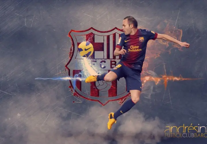 Andrés Iniesta w skoku kopie piłkę na tle herbu FC Barcelony.