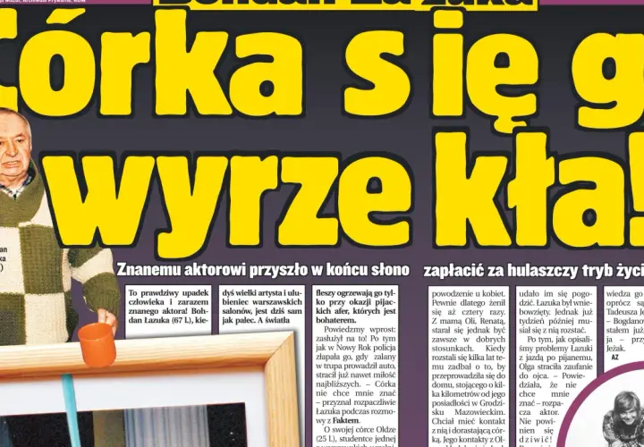 Bohdan Łazuka w swetrze w kratę, z pomarańczowym kubkiem.