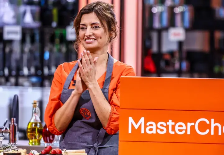 Barbara Tomkowiak w fartuchu MasterChef, z dłońmi złożonymi w geście radości.