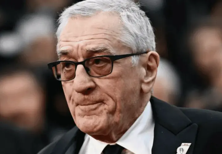 Portret Roberta De Niro w okularach, w garniturze.