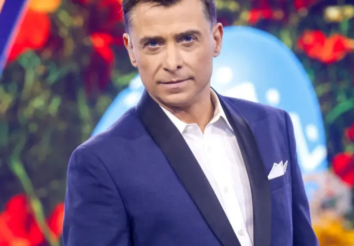 Kacper Kuszewski w granatowej marynarce z czarnym wyłogiem i białą koszulą.