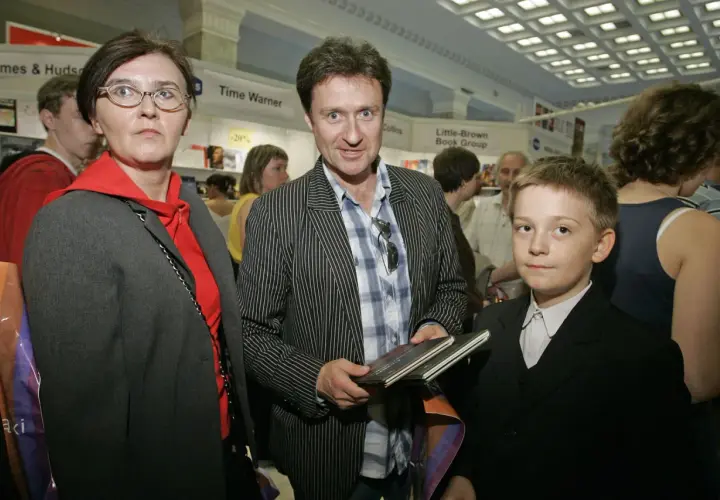 Kobieta w okularach, mężczyzna w marynarce w paski i chłopiec w garniturze.