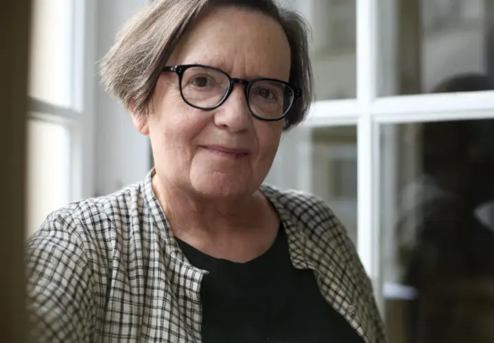 Portret starszej kobiety w okularach, w kratowanej koszuli.