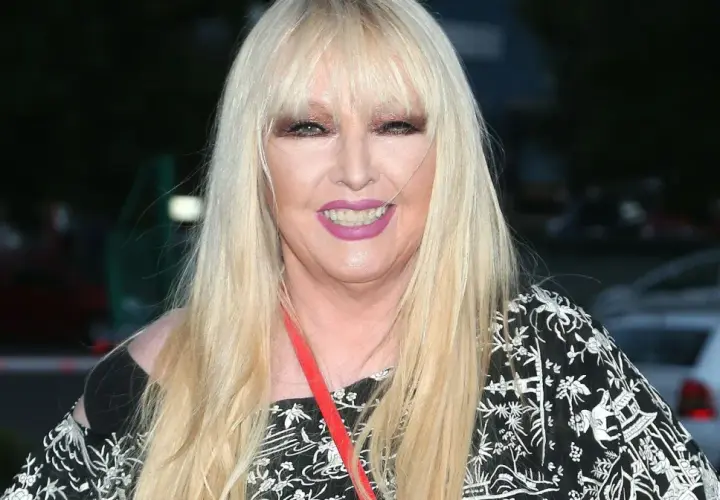 Maryla Rodowicz w czarno-białej sukience z ozdobnym wzorem, z długimi blond włosami i makijażem.