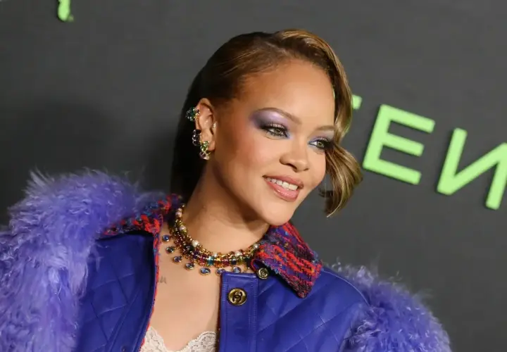 Rihanna w fioletowym futrze i biżuterii, z makijażem oczu.