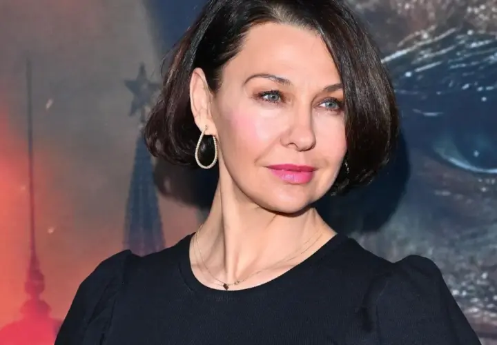 Portret Anny Popek w czarnej bluzce, z kolczykami i naszyjnikiem.