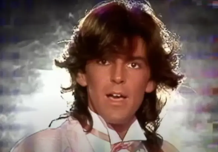 Thomas Anders z burzą włosów i w jasnej koszuli z krawatem.
