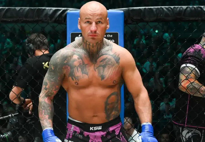 Artur Szpilka w ringu KSW, z tatuażami na klatce piersiowej i rękach.