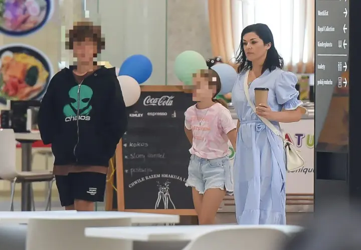 Kobieta w niebieskiej sukience z dwójką dzieci w centrum handlowym.
