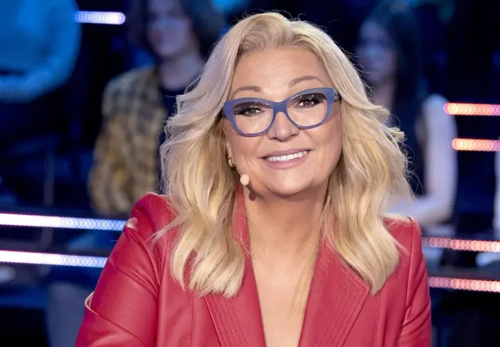 Małgorzata Walewska w czerwonej marynarce i okularach, uśmiecha się.