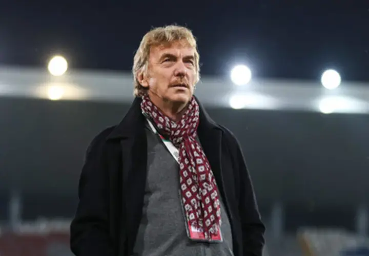 Zbigniew Boniek w płaszczu i szaliku na tle stadionu.