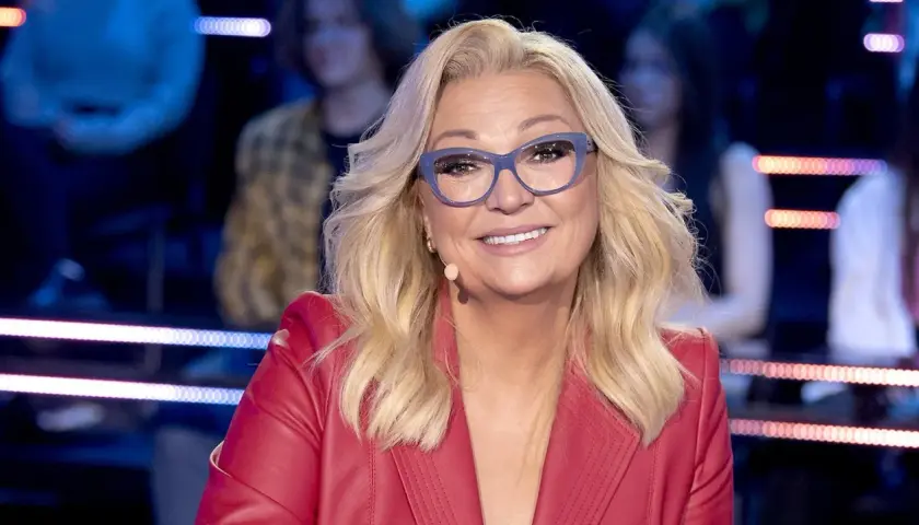 Małgorzata Walewska w czerwonej marynarce i okularach, uśmiecha się.