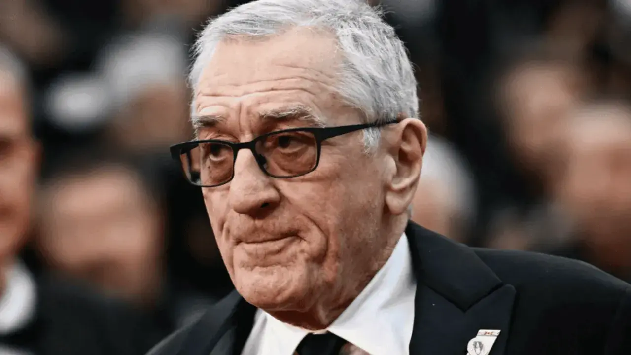 Portret Roberta De Niro w okularach, w garniturze.