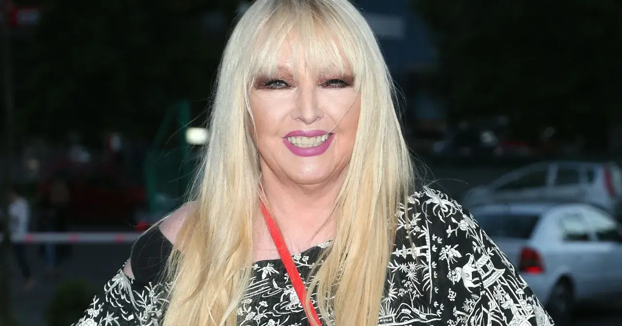 Maryla Rodowicz w czarno-białej sukience z ozdobnym wzorem, z długimi blond włosami i makijażem.