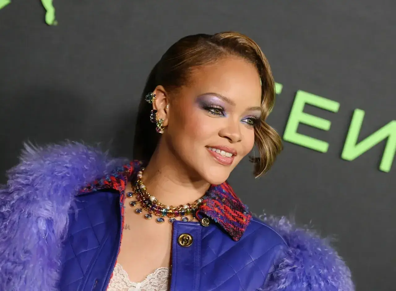 Rihanna w fioletowym futrze i biżuterii, z makijażem oczu.