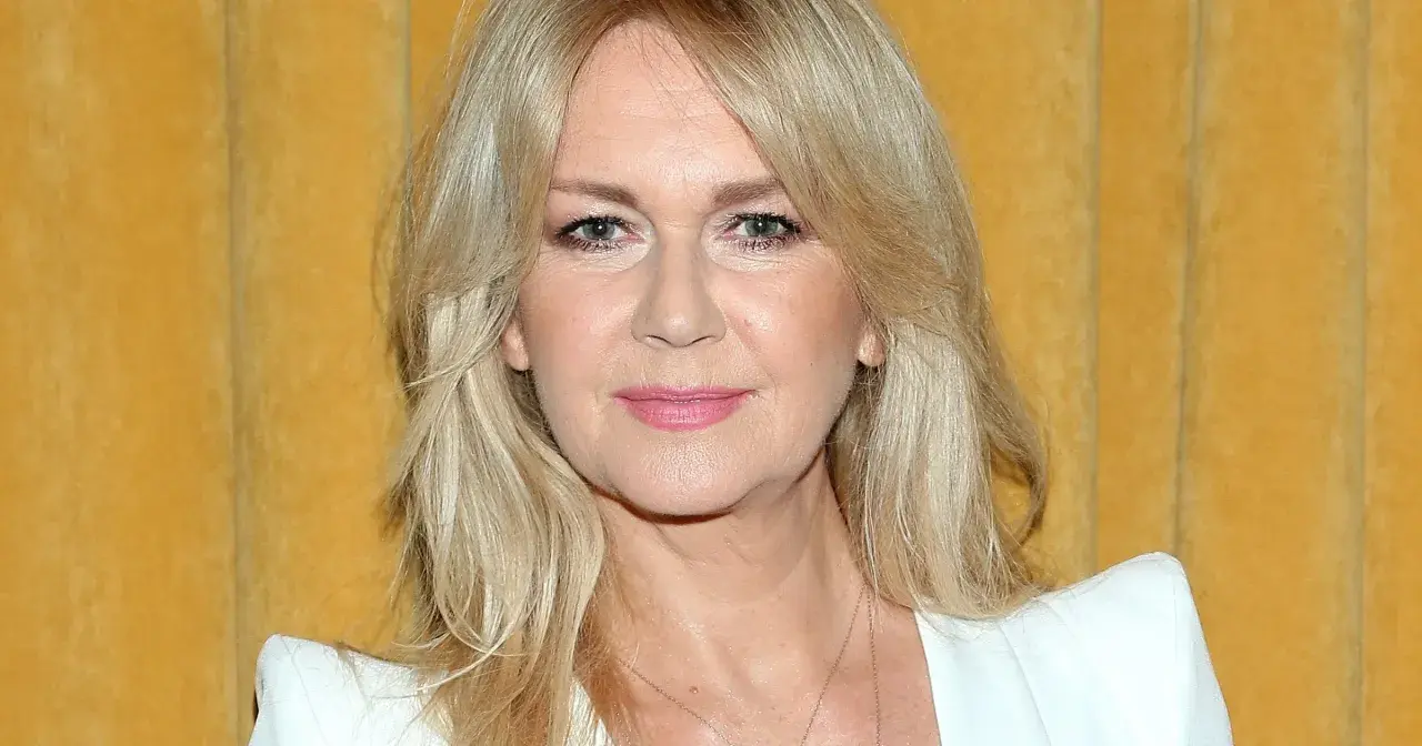 Portret Grażyny Torbickiej z blond włosami na tle żółtej zasłony.