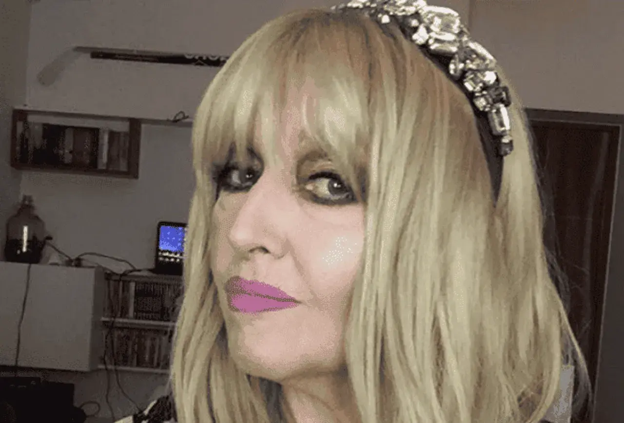 Portret Maryli Rodowicz z blond włosami, w opasce z cyrkoniami i różową szminką.